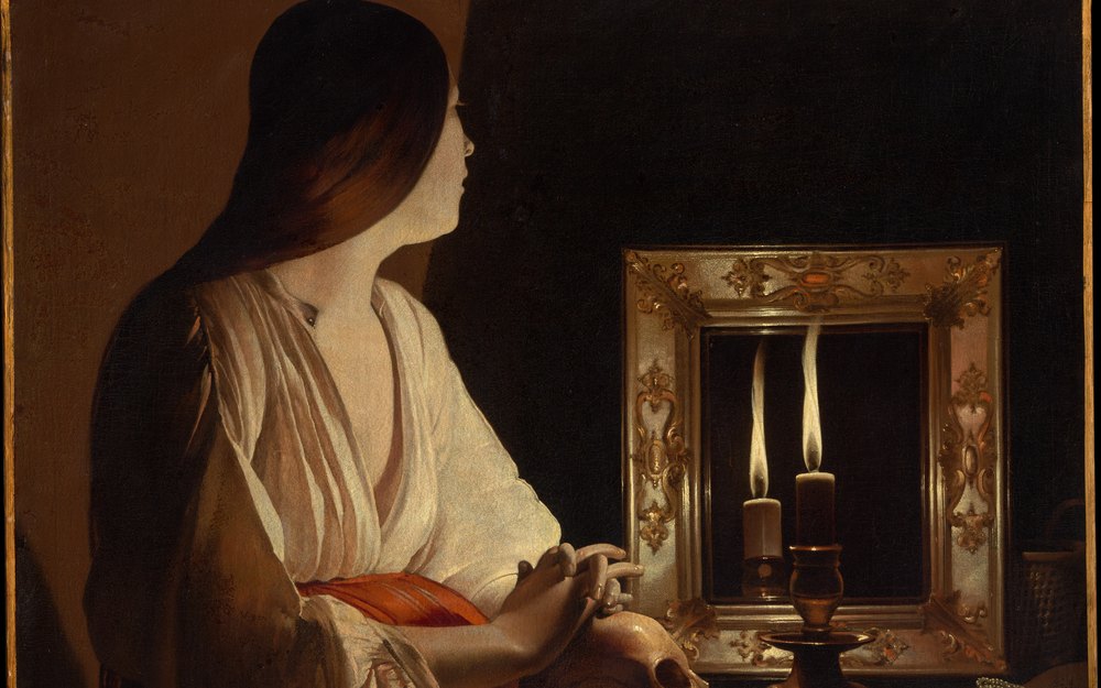ジョルジュ・ド・ラ・トゥール《悔悛するマグダラのマリア》（1640年頃）、メトロポリタン美術館。暗い部屋で、白いブラウスの女性が、鏡に映るろうそくの炎を見つめている油彩画の一部。