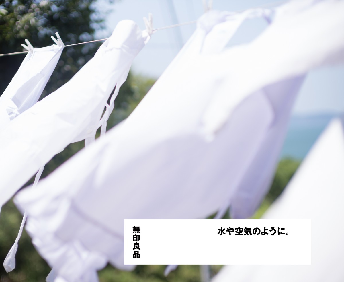 太陽の下の物干しロープに吊るされた白い洗濯物。画面右下の白い枠に「無印良品」と「水や空気のように。」の文字がある企業広告