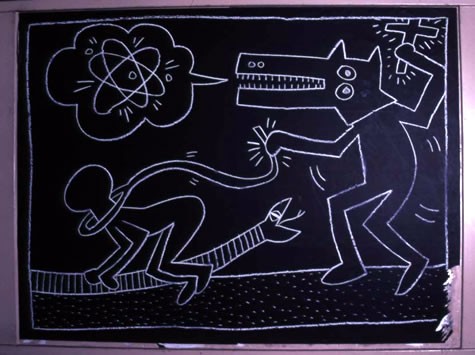 ニューヨークの地下鉄駅の黒い広告板に、白いチョークで描かれたサブウェイ・ドローイング。ワニのような動物と人物がリズミカルな太い線で描かれている