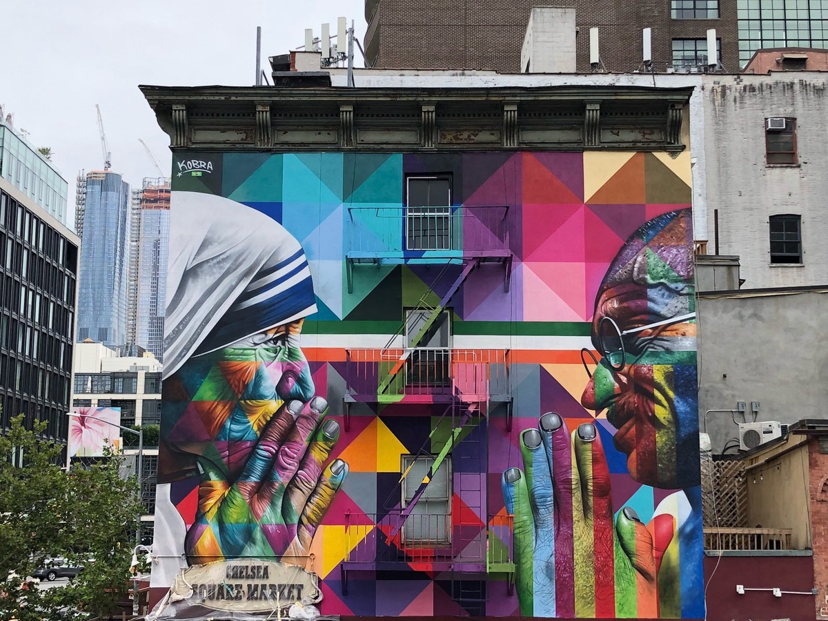 エドゥアルド・コブラの壁画『Tolerância』。ニューヨークの建物の壁の左にマザー・テレサ、右にマハトマ・ガンディーが手を合わせるように向かい合い、間を色とりどりの四角形が埋めている