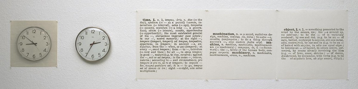 ジョセフ・コスース『Clock (One and Five), English/Latin Version』。白い壁の左から、紙に印刷された時計の写真、本物の壁掛け時計、英語とラテン語の辞書の項目を写した紙3枚が横一列に並ぶ